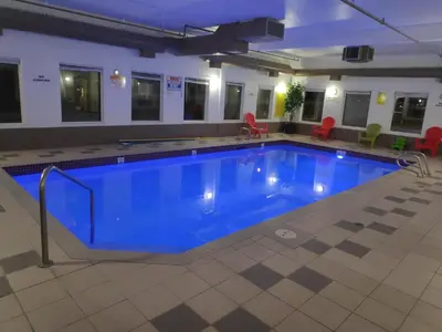 a large pool with blue water in a building at Super 8 by Wyndham Hinton-Free Breakfast,Wifi,Parking in Hinton