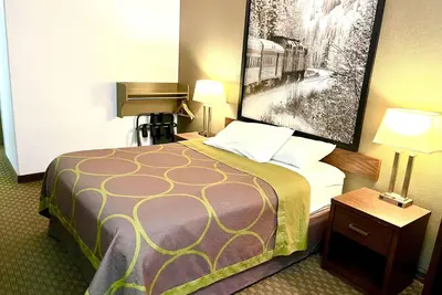 a hotel room with a bed and a picture on the wall at Super 8 by Wyndham Hinton-Free Breakfast,Wifi,Parking in Hinton