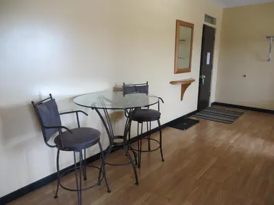 a table and chairs in a room with a hallway at Athabasca Valley Inn & Suites in Hinton