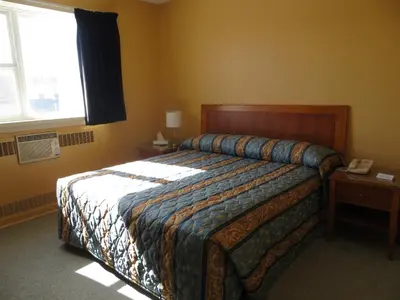 a bedroom with a bed and a window at Athabasca Valley Inn & Suites in Hinton