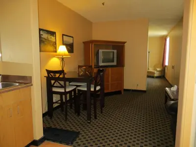 a hotel room with a table and chairs and a television at Athabasca Valley Inn & Suites in Hinton