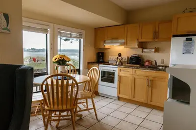 a kitchen with a table and chairs and a kitchen with a window at Beach Acres Resort in Parksville