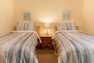 a bedroom with two beds and a lamp on a night stand at Beach Acres Resort in Parksville