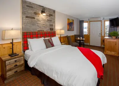 a bedroom with a large bed and a brick wall at Bear Hill Lodge in Jasper