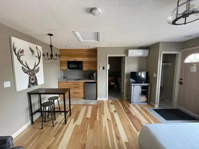 a bedroom with a kitchen and a dining room table at Bear Hill Lodge in Jasper