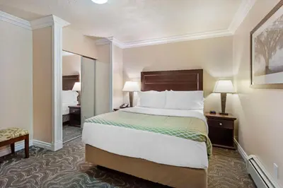 a hotel room with a bed and a mirror at Best Western PLUS Mirage Hotel and Resort in High Level