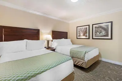 a hotel room with two beds and a chair at Best Western PLUS Mirage Hotel and Resort in High Level
