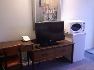 a television on a wooden table with a microwave at Caravan INN in Quesnel