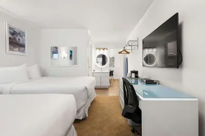 a hotel room with two beds and a desk at SureStay Hotel by Best Western Rossland Red Mountain in Rossland