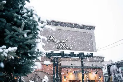 a sign for a regent hotel in the snow at Regent Hotel Revelstoke in Revelstoke