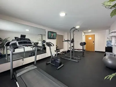 a gym with treadmills and ellipticals in a room at Howard Johnson by Wyndham Fort St. John in Fort Saint John