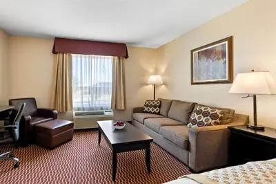 a hotel room with a couch and a chair at Best Western of Olds in Olds