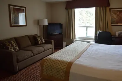 a hotel room with a bed and a couch at Best Western of Olds in Olds
