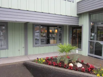 a building with a flower garden in front of it at Inn on the Harbour in Prince Rupert