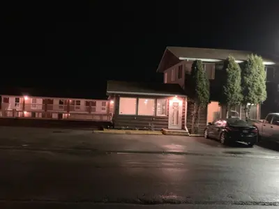 a house with a car parked in front of it at night at Airways Motel in Cold Lake