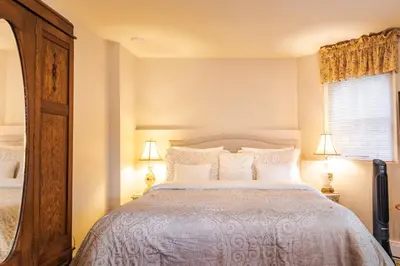 a bedroom with a large bed and a mirror at Amethyst Inn in Victoria