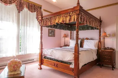 a bedroom with a four poster bed with a canopy at Amethyst Inn in Victoria