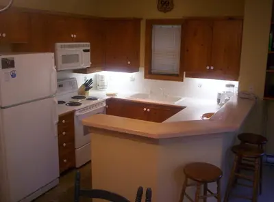 a kitchen with white appliances and wooden cabinets at Whistler Superior Properties in Whistler