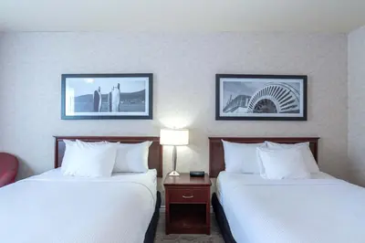 a hotel room with two beds and two lamps at Sandman Hotel Penticton in Penticton