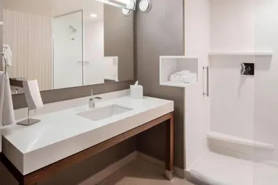 a white bathroom with a sink and a shower at Courtyard by Marriott Prince George in Prince George