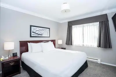 a hotel room with a large bed and a window at Sandman Hotel & Suites Prince George in Prince George
