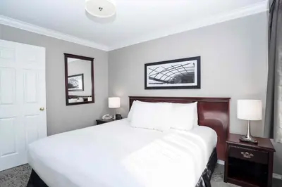 a bedroom with a large white bed with two lamps at Sandman Hotel & Suites Prince George in Prince George