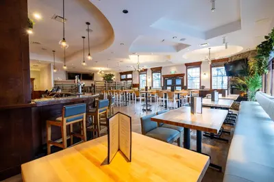 a restaurant with tables and chairs and a bar at Sandman Hotel & Suites Prince George in Prince George