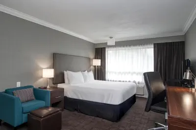 a hotel room with a bed and a blue chair at Sandman Hotel Revelstoke in Revelstoke