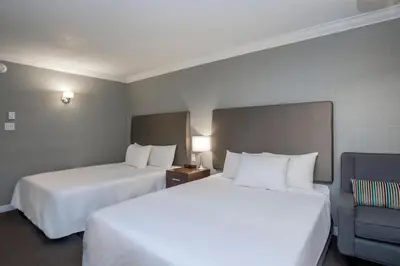 a hotel room with two beds and a chair at Sandman Hotel Revelstoke in Revelstoke