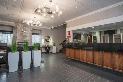 a lobby with a bar with plants in the middle at Sandman Hotel Revelstoke in Revelstoke