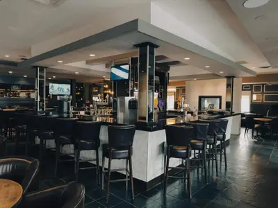 a bar with black stools in a restaurant at Super 8 by Wyndham Dawson Creek in Dawson Creek