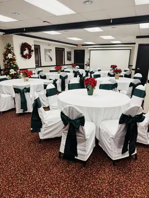 a conference room with white tables and chairs with bows at Super 8 by Wyndham Dawson Creek in Dawson Creek