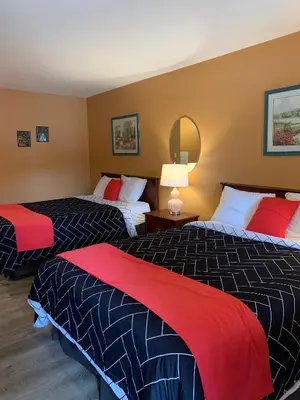 a hotel room with two beds with red and black sheets at Motel Bavaria in Radium Hot Springs