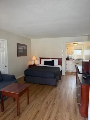 a bedroom with a bed and a living room at Motel Bavaria in Radium Hot Springs