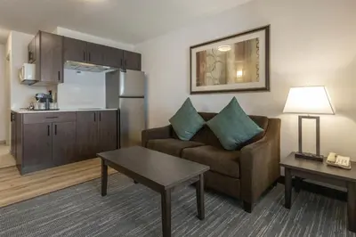 a living room with a couch and a kitchen at Best Western Dawson Creek in Dawson Creek