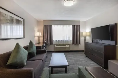 a hotel room with a couch and a flat screen tv at Best Western Dawson Creek in Dawson Creek
