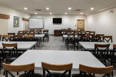a classroom with tables and chairs and a screen at Ramada Golden in Golden
