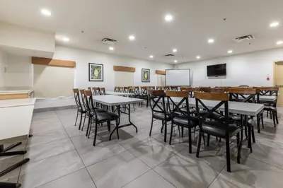 a dining room with tables and chairs and a screen at Ramada Golden in Golden