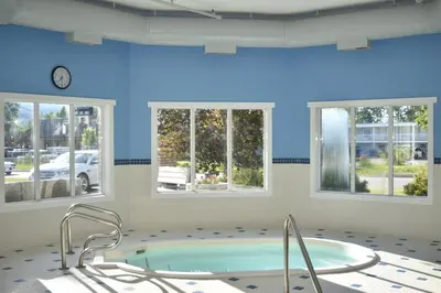 a large room with a hot tub and windows at Ramada Golden in Golden
