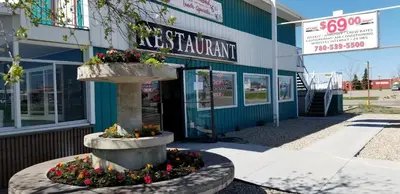 a store with a fountain in front of a building at Wild Rose Country Inn in Grande Prairie
