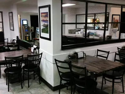 a restaurant with wooden tables and chairs and a counter at Wild Rose Country Inn in Grande Prairie