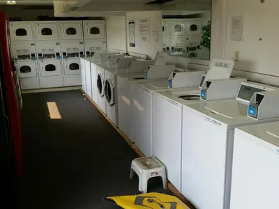 a laundry room with white washers and dryers at Wild Rose Country Inn in Grande Prairie