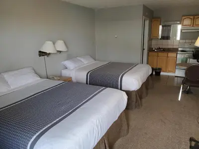 a hotel room with two beds and a kitchen at Wild Rose Country Inn in Grande Prairie