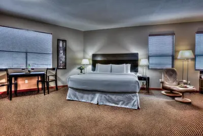 a bedroom with a bed and a desk and a chair at Podollan Inn & Spa - Grande Prairie in Grande Prairie