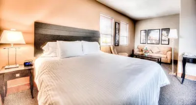 a hotel room with a large bed and a couch at Podollan Inn & Spa - Grande Prairie in Grande Prairie