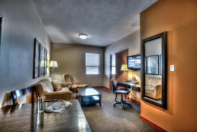 a living room with a couch and a desk at Podollan Inn & Spa - Grande Prairie in Grande Prairie
