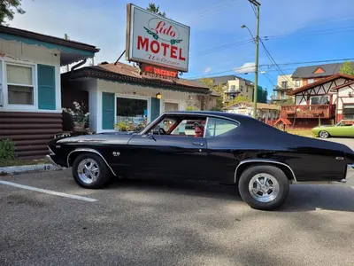 an old black car parked in front of a motel at Lido Motel in Radium Hot Springs