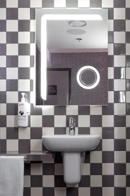 a bathroom with a sink and a mirror at Pangea Pod Hotel in Whistler