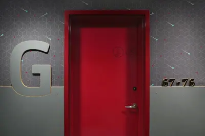 a red door with the letter c on a wall at Pangea Pod Hotel in Whistler