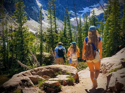 three people walking on a trail in the mountains at Mountain View Resort and Suites at Fairmont Hot Springs in Fairmont Hot Springs